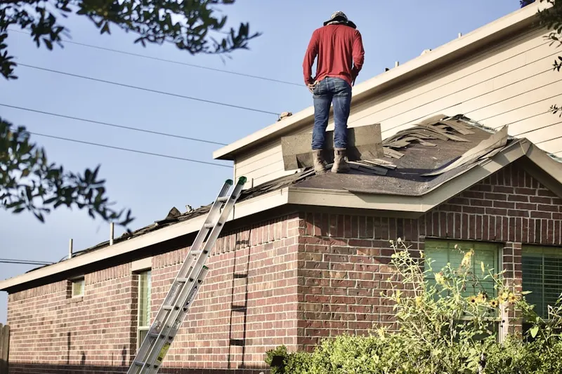 Professional roofer working on a residential roof in Elmer